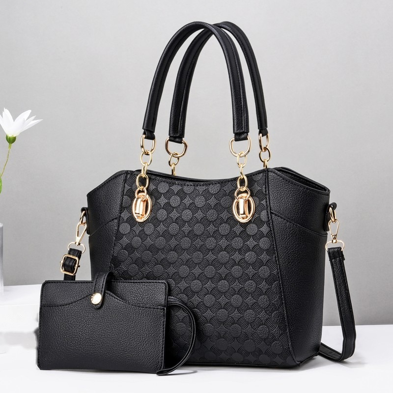 Schwarze Schultertasche mit Prägemuster, zwei Henkeln und kleinem schwarzem Täschchen davor